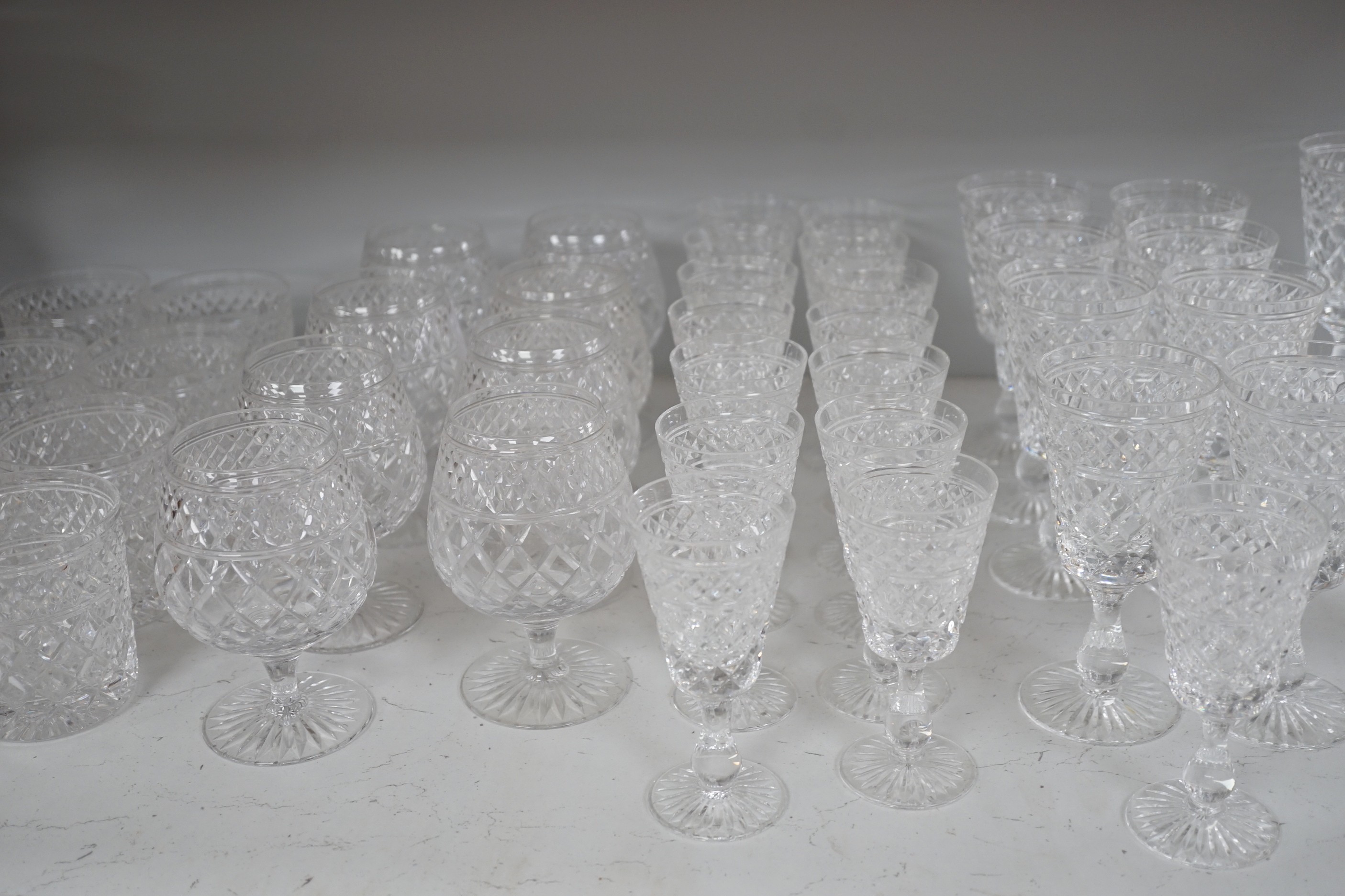 A quantity of Stuart cut glass suite of wine and spirit glasses and a similar pair of decanters